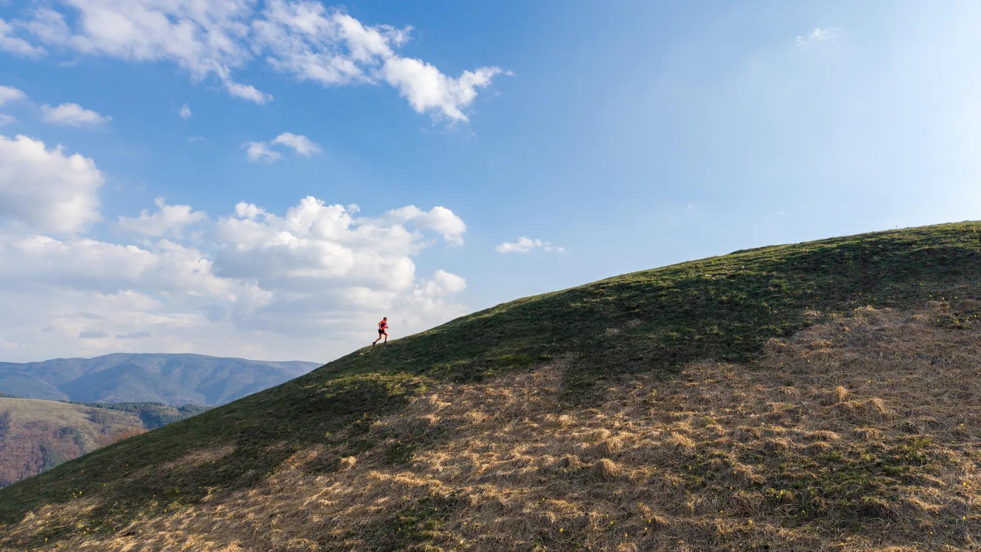 A woman is trail running in the mountain, the nature is beautiful.
